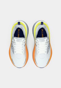 Bílé sportovní boty s síťovaným svrškem, šedými akcenty, neonově žlutými a oranžovými detaily a modrou logovou nášivkou na patě.