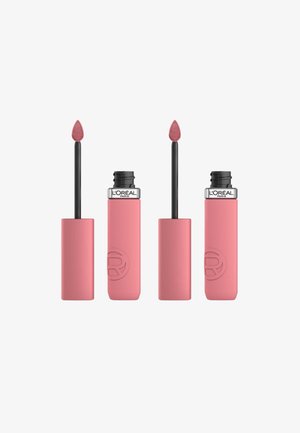 Des tubes de rouge à lèvres liquide rose avec une finition mate, dotés d'un applicateur en forme de pied de doe effilé. La marque est visible sur le capuchon noir.