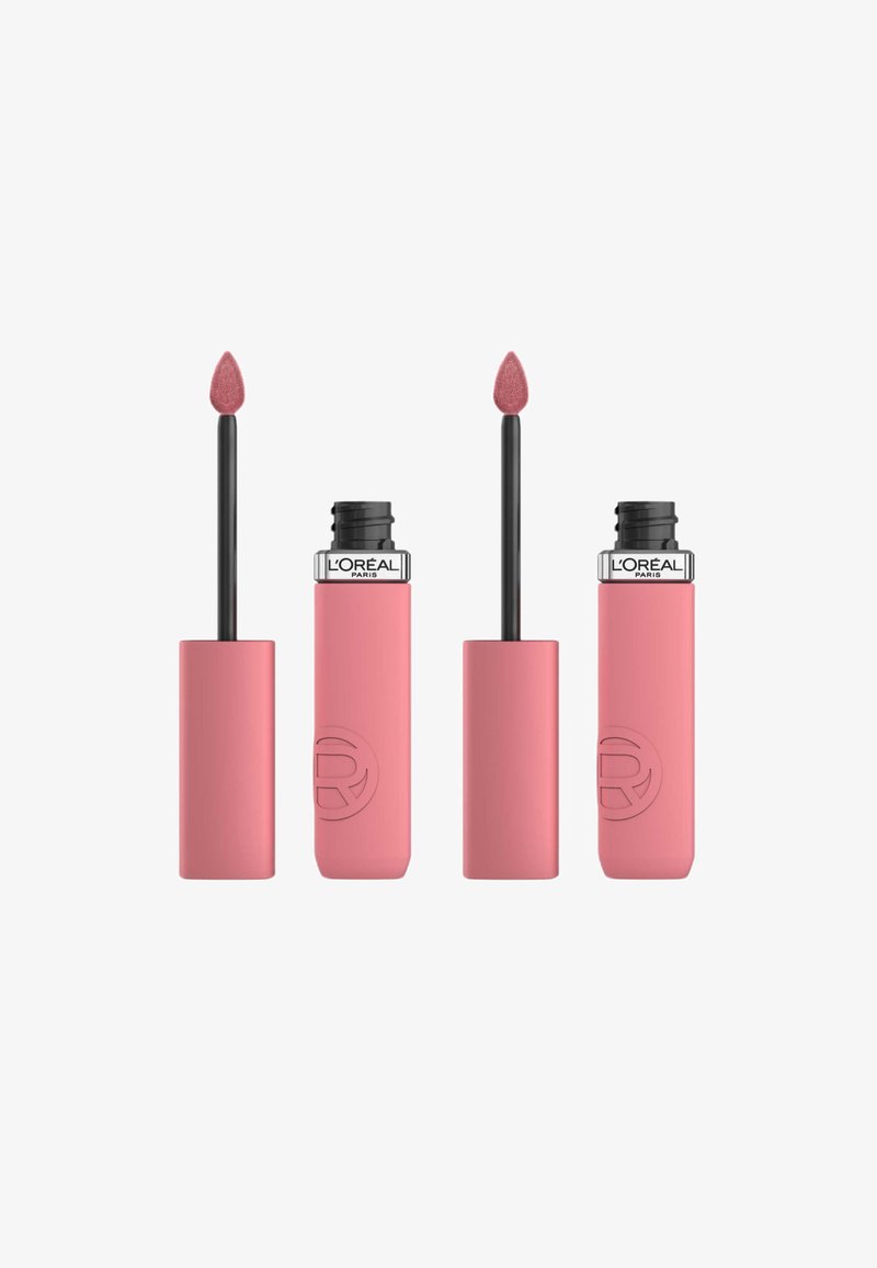 Des tubes de rouge à lèvres liquide rose avec une finition mate, dotés d'un applicateur en forme de pied de doe effilé. La marque est visible sur le capuchon noir.