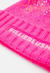 Løs rosa strikket lue med ribbet tekstur og spredte glitrende paljetter; trykt "BILLIEBLUSH"-logo på den brettede kanten.