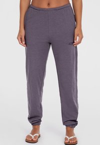 Jogger grigi leggeri con vestibilità rilassata, vita elastica e caviglie con polsini, caratterizzati da un logo discreto sul lato.