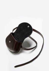 Borsa a tracolla in pelle marrone con forma arrotondata, internamente in suede e chiusura a scatto metallica. Dotata di una tracolla regolabile.