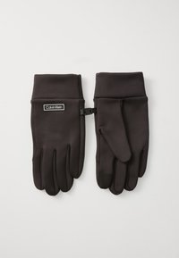 Schwarze Handschuhe aus einem weichen, glatten Stoff mit einem Logo-Patch und einem Riemen zur Sicherung. Die Finger sind verjüngt und besitzen eine touch-screen-kompatible Spitze.