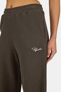 Tmavě hnědé žebrované tepláky s elastickým pasem, bočními kapsami a bílým logem "Pegador" na levém stehně.