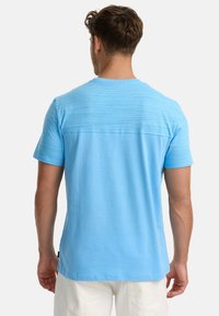 Blaues Kurzarm-T-Shirt mit strukturiertem Oberteil, rundem Ausschnitt und einer weichen Baumwollmischung. Verfügt über einen leicht abgerundeten Saum und ein Etikett an der Seite.