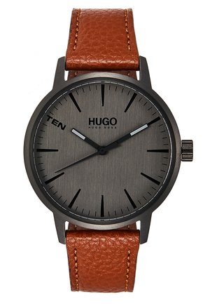 Rund sort metalur med mørkegrå urskive, sorte time markører, brun læderrem, teksten "TEN" ved kl. 10 og "HUGO BOSS" logo.