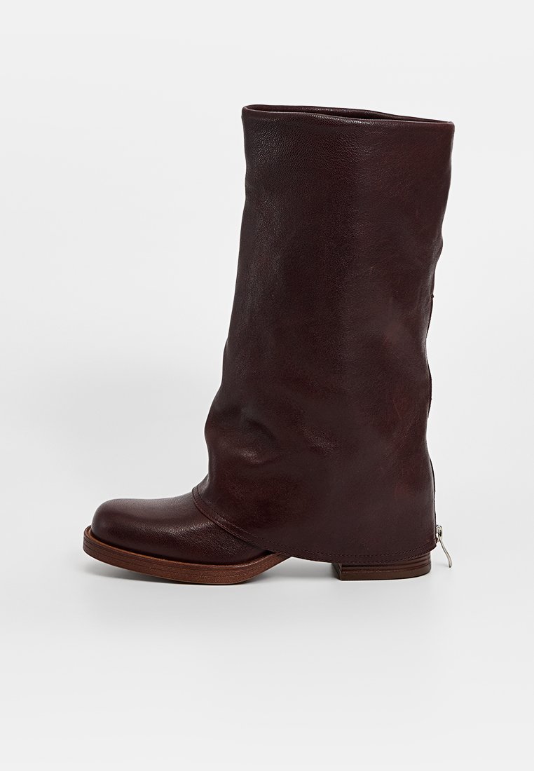 Botte en cuir marron haute, à design décontracté, bout rond et semelle en bois. Comprend une fermeture éclair sur le côté pour faciliter l'enfilage.