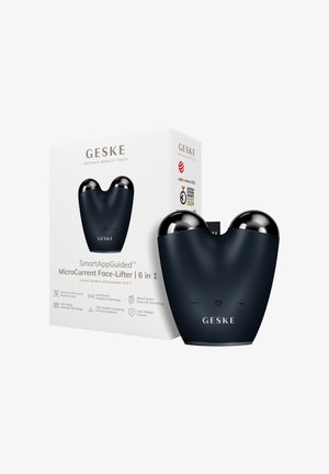 Zwart GESKE MicroCurrent Face-Lifter apparaat met twee afgeronde zilveren bollen, plus- en minknoppen, weergegeven naast zijn witte productdoos.