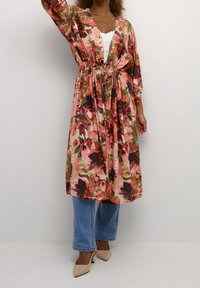 Blommig kimono-liknande morgonrock i rosa med gröna och svarta detaljer, som har en öppen front, breda ärmar och dragsko i midjan.