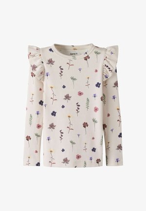 Camiseta infantil de manga larga color crema con patrones florales multicolores y detalles con volantes en los hombros, escote redondo.