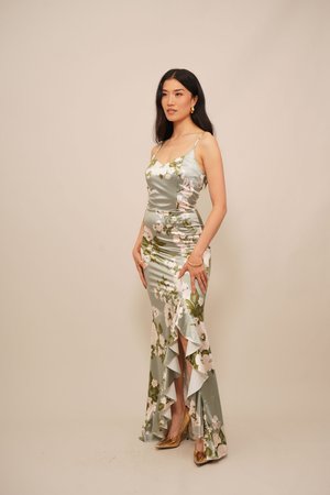 Rochie din satin cu imprimeu floral, verde deschis cu flori albe și roz, siluetă ajustată, tiv volanat, bretele tip spaghetti, asortată cu pantofi cu toc aurii.