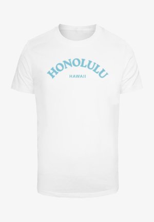 Biela bavlnená tričko s modrým zakriveným textom, ktorý znie "HONOLULU" a "HAWAII" nižšie. Hladká textúra, klasický strih, krátke rukávy.