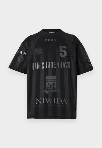 Črn športni dres z navpičnimi črtami, okroglim izrezom, kratkimi rokavi in različnimi natisnjenimi grafikami, vključno s številkami in besedilom.