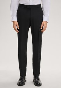 Schwarze Anzughose mit einem eleganten, maßgeschneiderten Design, mit glatter Textur und geradem Schnitt, kombiniert mit polierten schwarzen Schuhen.