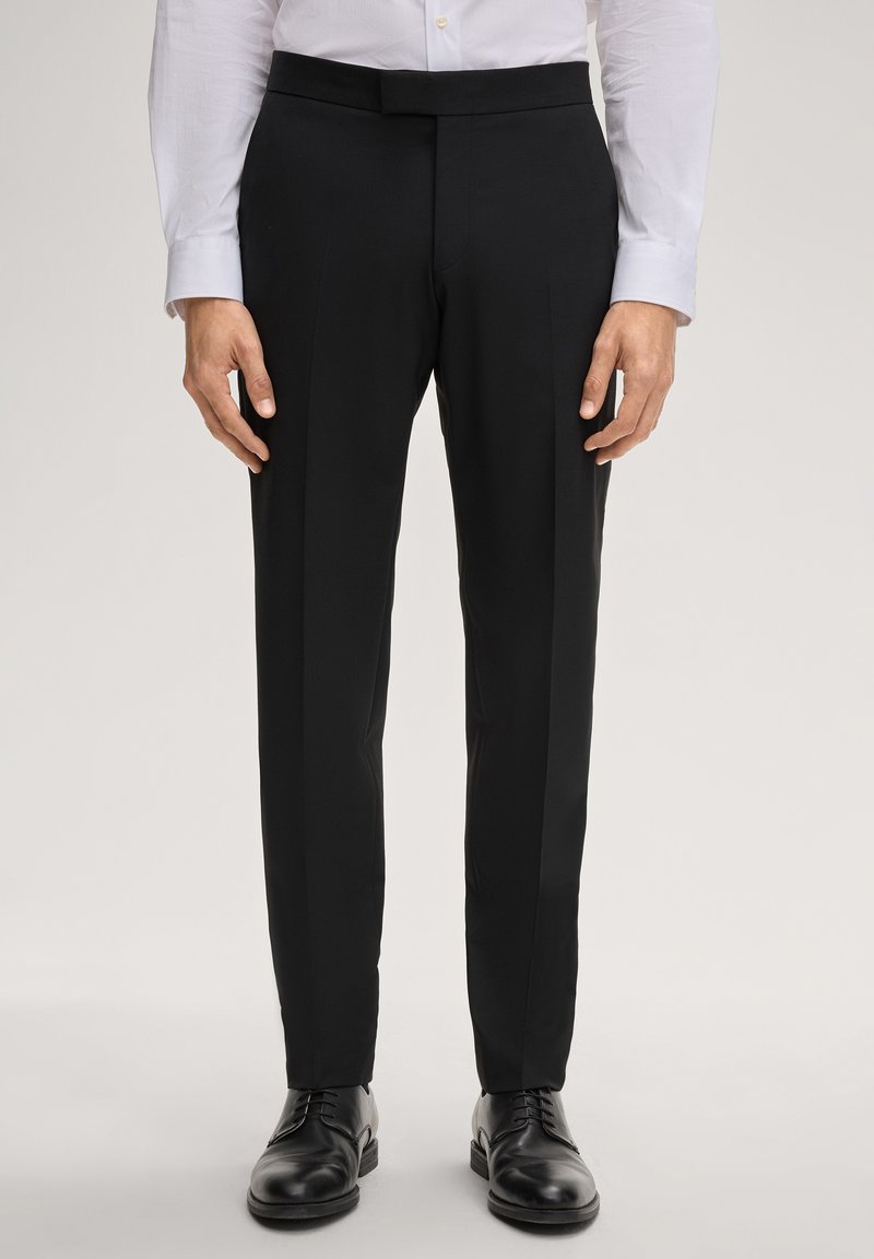 Schwarze Anzughose mit einem eleganten, maßgeschneiderten Design, mit glatter Textur und geradem Schnitt, kombiniert mit polierten schwarzen Schuhen.