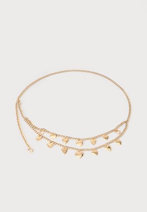 Collier chaîne en or avec deux rangées de petits charms en forme de cœur uniformément espacés le long des chaînes inférieures sur fond blanc.