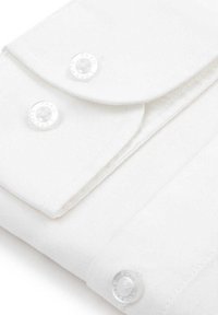 Biała tkanina o teksturowanym splocie, z zaokrąglonymi kieszeniami na klapki i przezroczystymi guzikami z grawerowanym zdobieniem. Prosty, elegancki design.