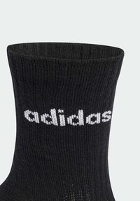 Czarne skarpetki ze ściągaczem, o prążkowanej strukturze. Z białym logo "adidas" po boku. Wykonane z rozciągliwego, teksturowanego materiału.