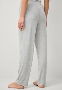 Grijze, loszittende broek gemaakt van zachte stof, met een elastische tailleband, rechte pijpen en zonder zichtbare patronen of accenten.