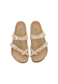 Light beige sandals with double adjustable straps and silver buckles. Cork footbed with green logo, textured rubber sole.