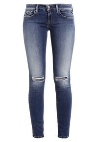 Vaqueros skinny fit en denim azul oscuro, con desgarros en las rodillas y un acabado desgastado, con pasadores para cinturón estándar y bolsillos frontales.