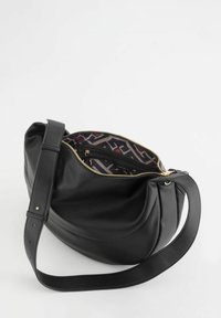 Bolso de hombro de cuero negro con superficie texturizada, cierre de cremallera dorado y forro de tela estampada con diseños geométricos.