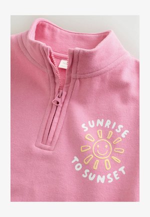 Różowy polar z kołnierzem na zamek. Zabawna grafika słońca i tekst "SUNRISE TO SUNSET" w kolorach białym i żółtym.