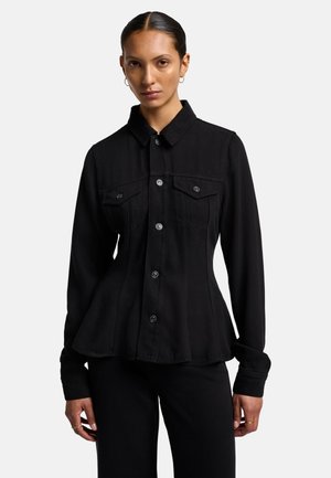 Chemise en denim noir avec un design ajusté, des manches longues, un devant à boutons et deux poches poitrine. Elle présente un col classique et des coutures visibles.