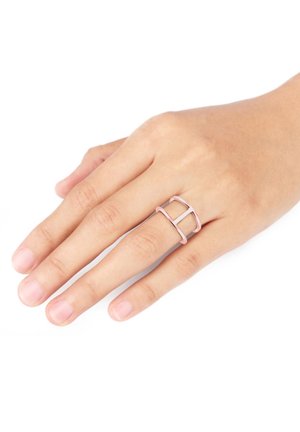 Rosa metallic Ring mit einem offenen, geometrischen Design aus geraden Linien. Auf einer Hand positioniert, vor einem neutralen Hintergrund.