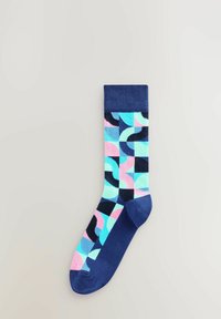Farverig bomuldsstrømpe med et mønster, der viser geometriske former i pink, blå og marineblå. Ribbet kant øverst.