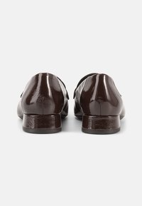 Καφέ λουστρίνι μοκασίνια με ομαλή, γυαλιστερή υφή και χαμηλό τετράγωνο τακούνι. Διαθέτουν κομψό σχεδιασμό και μινιμαλιστικές λεπτομέρειες.