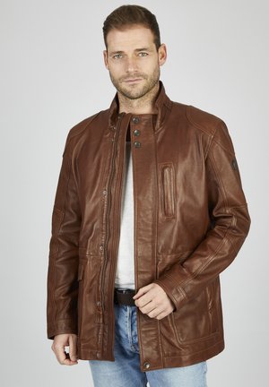 Chaqueta de cuero marrón con cuello alto, cierre de presión y cremallera, bolsillos frontales y acabado texturizado. Diseño casual adecuado para varias ocasiones.