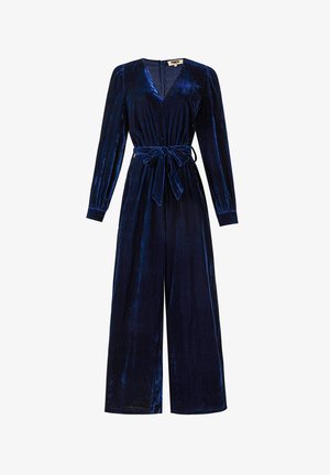 Donkerblauw fluwelen jumpsuit met lange mouwen, diepe V-hals, taillekoord en wijd uitlopende pijpen. Zachte textuur met subtiele glans.