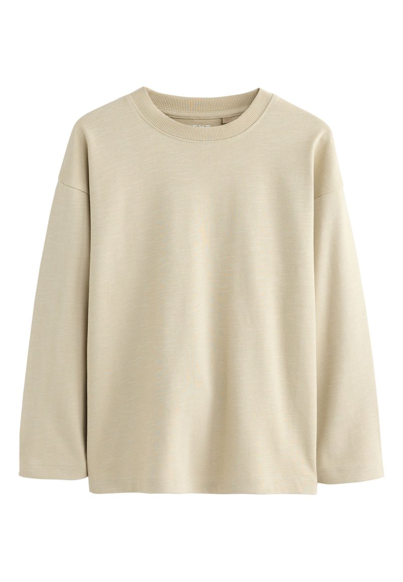 Beež värvi pikkade varrukatega T-särk, valmistatud pehmest puuvillast, millel on ümara kaelusega, lõdva istuvusega ja õrnalt tekstureeritud pind. Ei mingeid mustreid ega aktsente.