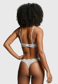 Grau meliertes Baumwoll-Lingerie-Set mit dünnen Trägern, elastischem Band mit Logo und Tanga-Design. Von hinten betrachtet.