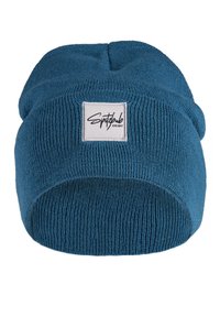 Blue knit beanie with a ribbed texture and folded brim. Features a white rectangular label with black text on the front.