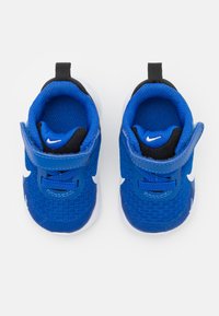 Baskets en mesh bleu avec le swoosh blanc de Nike, accents noirs et bande auto-agrippante. Présentent une surface texturée et un intérieur rembourré.