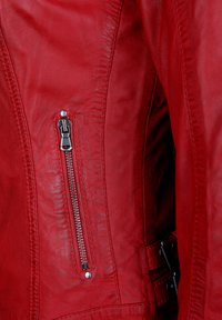 Rote Lederjacke mit glatter Textur, ausgestattet mit einem silbernen Reißverschluss und einem metallenen Verschluss sowie detaillierten Nähten entlang der Säume.