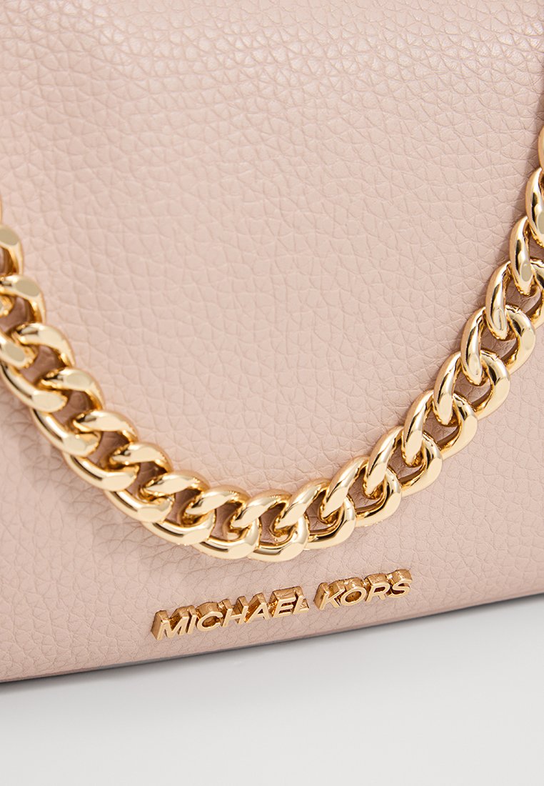 Hellrosa, strukturiertes Lederhandtasche mit einem dicken Goldkettentragegurt und goldenem "Michael Kors"-Logo auf der Vorderseite.