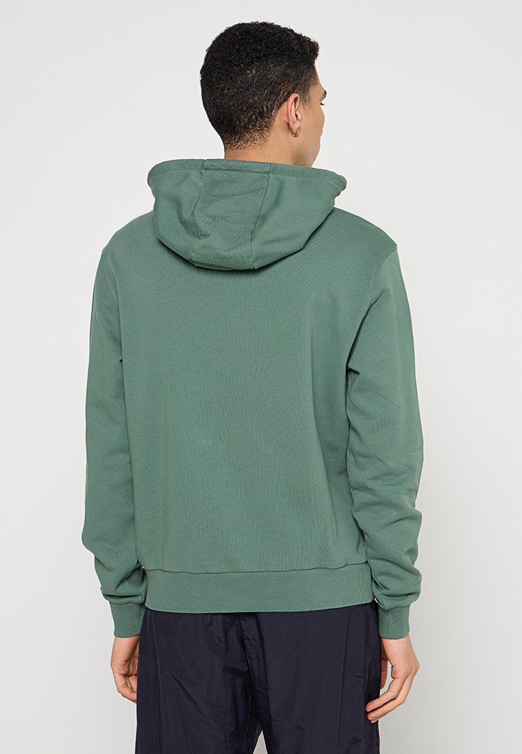 Grüner Baumwollhoodie mit strukturiertem Finish, ausgestattet mit einer Kapuze mit Kordelzug und gerippten Bündchen. Das Design ist einfach und lässig.