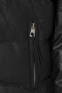 Schwarze Steppjacke mit einer strukturierten Kunstleder-Oberfläche, einer Reißverschlusstasche mit silbernen Beschlägen und einem verstellbaren Zugband am Kragen.