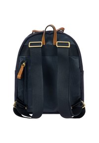 Zaino nero con spallacci regolabili, manico in pelle marrone e zip, e fibbie in metallo dorato su sfondo bianco.