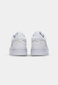 Białe sneakersy z teksturowanej skórzanej cholewki, wyraźnym wyściełanym kołnierzem i płaską gumową podeszwą. Posiadają małe złote logo na pięcie.