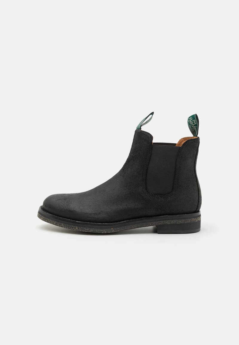 Botine Chelsea din suede negru, cu panouri elastice laterale și un tab de prindere. Talpă plată cu o ușoară textură, vârf rotunjit și detalii minime de cusătură.