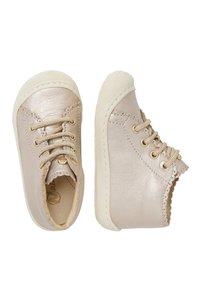 Dětské boty na šněrování z metalického béžového leatheru, se zvlněnými okraji, gumovou podrážkou a zlatými očky pro trvanlivost a podporu.