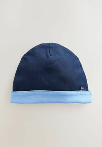 Sötétkék sapka világoskék szegéllyel, puha anyagból készült; oldalt egy kis fekete címke található "BAKER" felirattal.