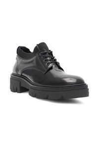 Pantof cu piele patent neagră, cu talpă masivă, design cu șireturi și guler căptușit. Prezintă o textură netedă și o siluetă robustă.