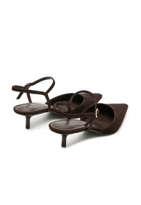 Scarpe slingback in suede marrone con punta appuntita, sottili cinturini alla caviglia e un piccolo tacco a blocco. Texture liscia e dettagli minimi.