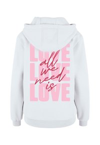 Sudadera blanca con un gran gráfico rosado en la parte posterior que dice "todo lo que necesitamos es AMOR" en diferentes tipografías y tamaños. Textura suave, diseño informal.