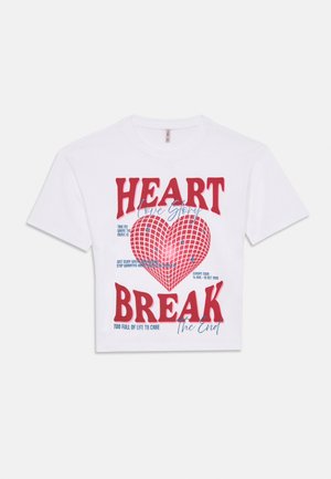 Valge lühikeste varrukatega T-särk suure punase südame graafikuga ja paksude punaste tähtedega tekstiga "HEART BREAK" ning väiksemate siniste käsitsi kirjutatud ja tekstidetailidega.